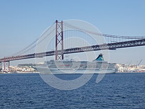 A cruise ship sails under the bridge of April 25 in Lisbon, Portugal, Europe
