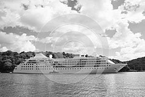 Cruise ship at seacoast in Fowey, United Kingdom. Ocean liner in sea on cloudy sky. Summer vacation on tropical island