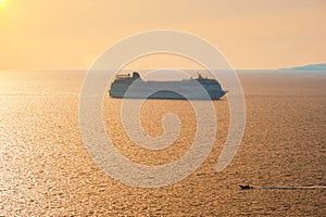 Cruise ship silhouette in Aegean sea on sunset