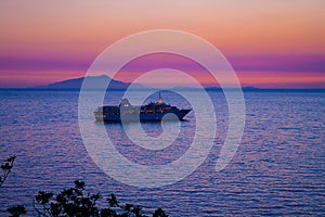 Cruise ship at sunset with the isle of ischia in background