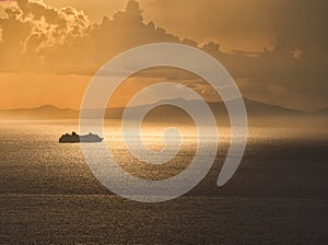 Cruise ship at sunset in thyrrenian sea with Eolian island in background