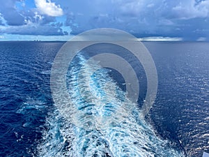 A Cruise ship wake on a beautiful stormy day with dark clouds and blue seas