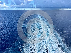 A Cruise ship wake on a beautiful stormy day with dark clouds and blue seas