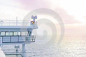 Cruise ship white cabin with big windows. Wing of running bridge of cruise liner. White cruise ship on a blue sky with radar