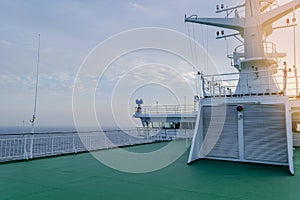 Cruise ship white cabin with big windows. Wing of running bridge of cruise liner. White cruise ship on a blue sky with radar and