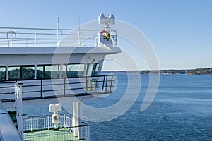 Cruise ship white cabin with big windows. Wing of running bridge of cruise liner. White cruise ship on a blue sky with radar and