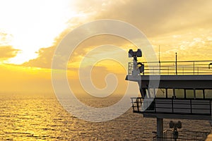 Cruise ship white cabin with big windows. Wing of running bridge of cruise liner. White cruise ship on a blue sky with radar and n