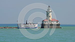 Cruise sight seeing ship passes by the Chicago harbor lighthouse