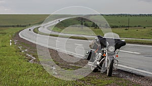 Cruiser motorcycle stopped by the road in the rain.