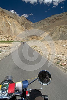 Cruising on a motorcycle on the road to Nubra valley among the picturesque Himalaya mountains in Ladakh region, India.