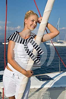 Cruising: Sailing woman on a luxury sail boat in summer.