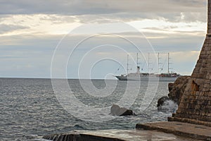 Cruising ship going from behind the old fortress with beautiful dramatic sunset