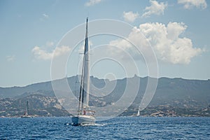 Cruising yacht in a blue waters of Mediterranean sea, Sardinia island.