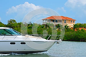 Cruising yacht bow with mansion in background
