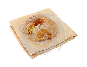 Cruller doughnut on cloth napkin bitten
