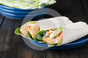 Crumbed fish fillet burrito with avocado and tomato