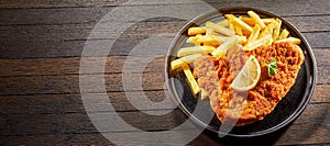 Crumbed fried fish or schnitzel with French fries photo