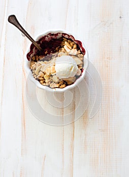 Crumble with blackberries, apples, almond and ball of vanilla ice cream