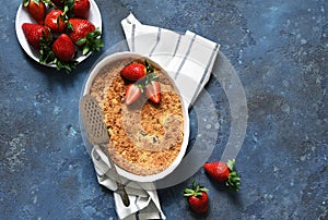 Crumble with strawberries on a benton background. View from above