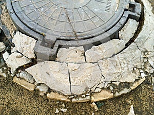 Crumbled concrete at the mouth of the manhole