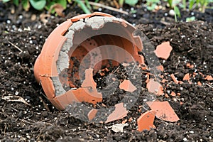 crumbled earthenware pot in garden soil