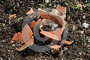 crumbled earthenware pot in garden soil