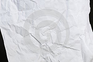 Crumbled paper top view close-up of crumpled sheet of white paper. Top view textured paper background, dark concrete