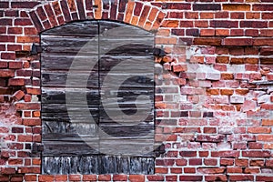 Crumbling brick wall of an old german warehouse with closed shutters