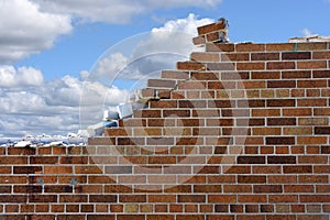 Crumbling brick wall with sky background