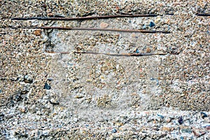 Crumbling concrete wall, horizontal bars, rusty armature. Damage rough cement