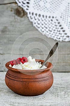 Crumbly homemade cottage cheese  in a clay pot