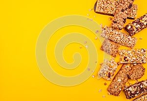 Crumbs and pieces of granola bars on yellow background