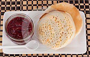 Crumpets and raspberry jam in a reusable glass jar