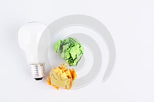 Crumple paper and bulb over white background