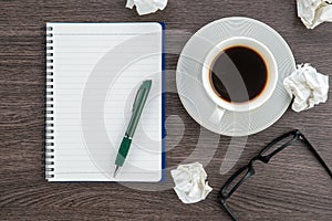 Crumple paper, notebook and pen with cup of coffee