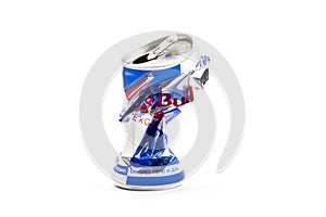 Crumpled aluminum can of RedBull drink over white background