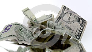 Crumpled american dollar banknotes bills rotating on isolated white background