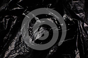 Crumpled Black Plastic Bag texture background. Glossy polyethylene overlay