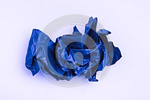 Crumpled blank sheet of colored blue paper on a white background. Top view