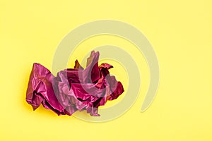 Crumpled blank sheet of colored violet paper on a yellow background. Top  view