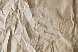 Crumpled craft paper background. Texture of brown crumpled paper, top view.