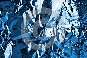 Crumpled dark blue foil shining texture background, bright shiny cold icy design, metallic glitter surface