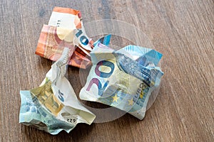 Crumpled euro money on a wooden background. Money in the period of inflation.