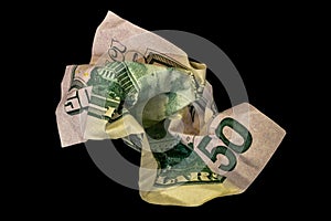 Crumpled fifty dollar bill isolated on black background