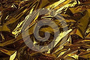 Crumpled foil texture background, close up golden foil