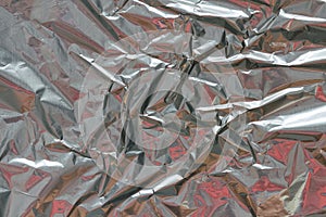 Crumpled foil texture background. Metal paper shit. Silver aluminum surface. Gift wrapping shiny paper. Glitter effect.