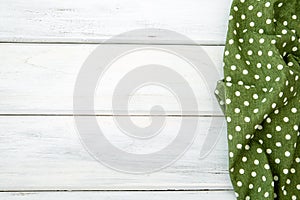 Crumpled green checkered tablecloth or napkin on empty white woo
