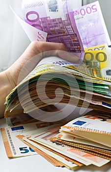 Crushing with a hand a five hundred euros banknote.