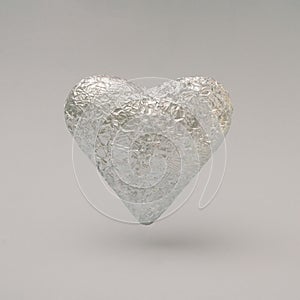 Crumpled large silver heart made of aluminum foil. Minimal concept of Valentine\'s Day with a gray background