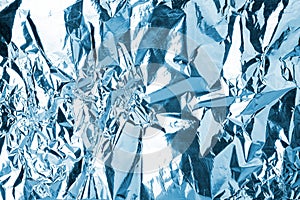 Crumpled light blue foil shining texture background, bright shiny cold icy design, metallic glitter surface